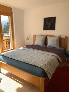 a bedroom with a large bed with a window at Apartment Number 8 in Crans-Montana