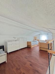 a large room with two beds and a room with wooden floors at Baška Voda - Apartmani Vesna in Baška Voda