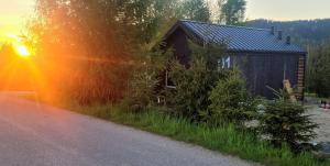 eine Hütte am Straßenrand mit Sonnenuntergang in der Unterkunft Domki na Widoku in Lubomierz