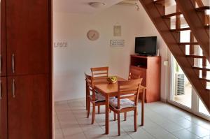 a dining room with a table and chairs and a television at Apartment Carole in Trogir
