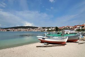 two boats sitting on the shore of a beach at Apartment Carole in Trogir