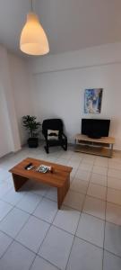 a living room with a coffee table and a tv at KANALI HOLIDAYS APARTMENT in Kanali