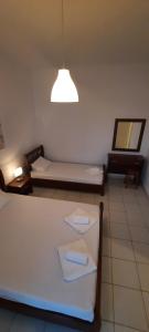a room with two beds and a light at KANALI HOLIDAYS APARTMENT in Kanali
