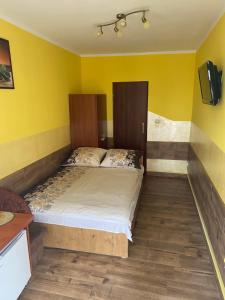 a bedroom with a bed in a yellow room at Limba II in Łeba