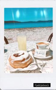 einen Tisch mit einem Donut und einem Glas Orangensaft in der Unterkunft Apartman Karla in Jadrija