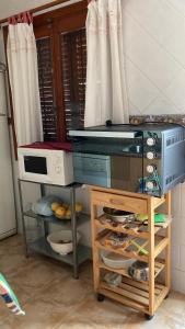 eine Küche mit Mikrowelle und einem Tisch mit Essen in der Unterkunft Duplex familiar in Puerto de Mazarrón + 11 Fotos