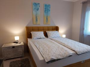 ein Schlafzimmer mit einem Bett und einem Nachttisch mit zwei Lampen in der Unterkunft Family apartment Cathy in Galižana