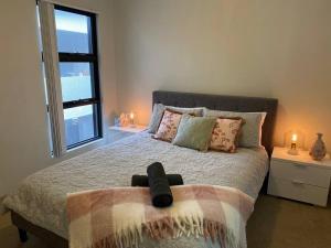 a bedroom with a bed with a large window at Stylish Modern Airport City WIFI Park Netflix Wine in Perth