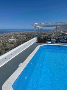 a swimming pool with a view of the ocean at Belle Etoile Villas in Imerovigli