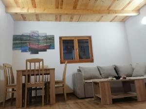 a living room with a couch and a table and chairs at BUNGALOVI TIM in Žabljak +40 photos
