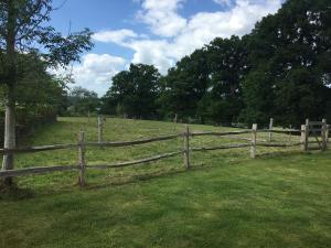a wooden fence in the middle of a field at Long Hoyle Annexe in Heyshott