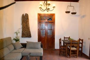 a living room with a couch and a table and a door at Finca Mariola - Centenaria in Las Palmas de Gran Canaria