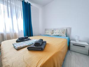 a bedroom with a bed with two towels on it at Apartament Zarnesti „Saturn” in Zărneşti
