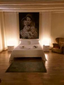 a bedroom with a painting of a woman holding a baby at Palazzo Gancia holiday homes in Syracuse