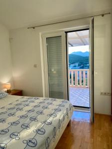 a bedroom with a bed and a view of a balcony at Apartmani Luka in Korčula