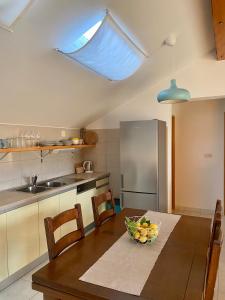 a kitchen with a table with a bowl of fruit on it at Apartmani Luka in Korčula