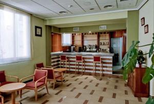 a room with a kitchen with chairs and a bar at Hostal Plaza Mayor in Torrejón de Ardoz