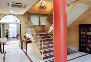 a spiral staircase in a room with a red pole at Hostal Plaza Mayor in Torrejón de Ardoz