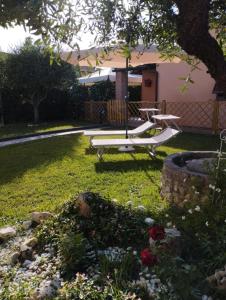 een tuin met een bank en een boom in een tuin bij Melody house - dépendance in Castiglione del Bosco