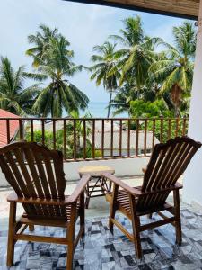 2 sillas y una mesa en un balcón con vistas al océano en Beachbliss Home Stay, en Arugam Bay