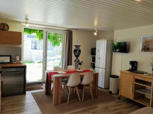 een keuken met een tafel met stoelen en een koelkast bij Villa Athéna,séjour bien-être et éthique in Meuvaines