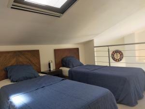 um quarto com 2 camas com lençóis azuis e um relógio em VILLA CAREMEAU 2 em Nîmes