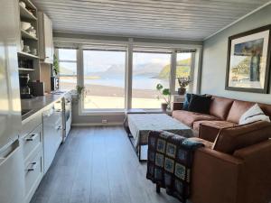 a living room with a couch and a large window at Loftsleilighet midt i sentrum in Skjervøy