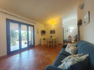 a living room with a blue couch and a table at Casa Vacanze VILLA SANDRINA in Costa Paradiso