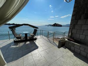 a patio with a table and chairs and the water at Apartments Lungo Mare in Sveti Stefan