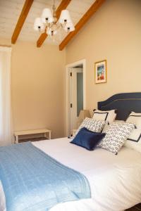 um quarto com uma cama grande e almofadas azuis em O Faro da Garita em Aldán