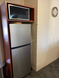 Un four micro-ondes est installé au-dessus d'un réfrigérateur. dans l'établissement SUBI CENTRAL CLOSE CBD HOSPITALS WIFI NETFLIX WINE, à Perth