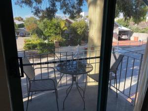 a patio with a table and chairs on a balcony at SUBI CENTRAL CLOSE CBD HOSPITALS WIFI NETFLIX WINE in Perth