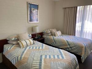 two beds sitting next to each other in a bedroom at SUBI CENTRAL CLOSE CBD HOSPITALS WIFI NETFLIX WINE in Perth +10 photos