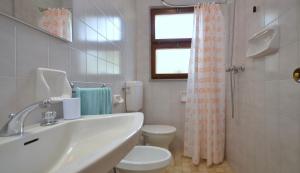 e bagno con lavandino, servizi igienici e doccia. di Villa Rosanna a Lignano Sabbiadoro