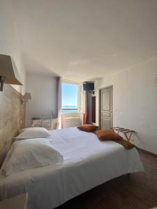 uma grande cama branca num quarto com uma janela em U Sant'Agnellu em Rogliano