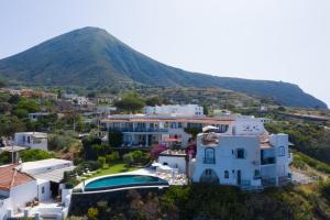 une vue aérienne sur une maison avec une montagne en arrière-plan dans l'établissement Hotel Punta Scario, à Malfa