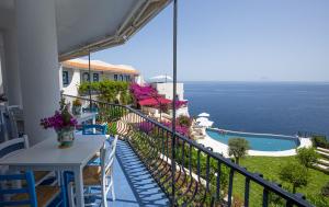 a balcony with a table and a view of the ocean at Hotel Punta Scario in Malfa