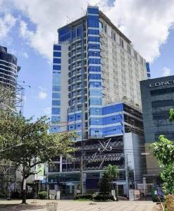 a large building with a sign in front of it at Inspiria Cozy Condo in Cabaguio