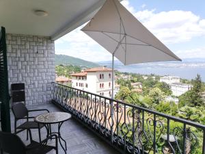 a balcony with a table and an umbrella at Villa Allegra 1 in Lovran