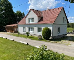 a white house with a red roof on a road at Ubytování u Knotků in Nová Bystřice