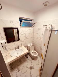 uma casa de banho com um lavatório, um WC e um espelho. em KRIS Guesthouse em Berat