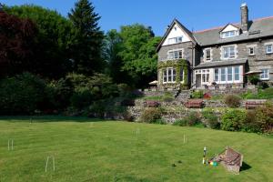 a large house with a yard with a baseball game on the lawn at Sawrey House in Near Sawrey