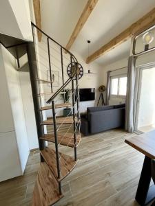 eine Wendeltreppe in einem Raum mit einem Wohnzimmer in der Unterkunft Duplex Centre Ville - 50m de la Plage - Clim - Garage - Netflix in Le Grau-du-Roi