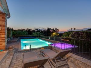a swimming pool with two chairs next to a fence at Villa Salvea with heated pool in Montižana