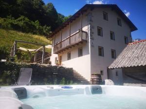 a house with a hot tub in front of a building at Apartment Abinkar in Tolmin