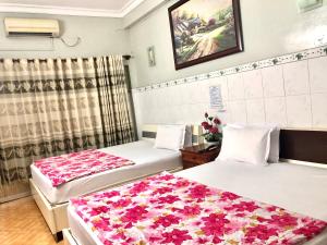 a hotel room with two beds with flowers on them at Khách Sạn Hồng Hà 2 in Ho Chi Minh City