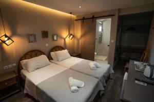 a bedroom with two beds with towels on them at Parthenis Riviera Hotel in Athens
