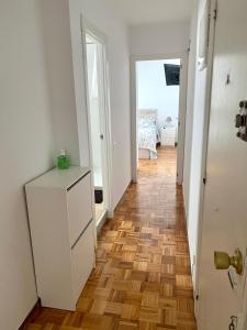 a hallway with a white cabinet and a wooden floor at Engoco in Gijón