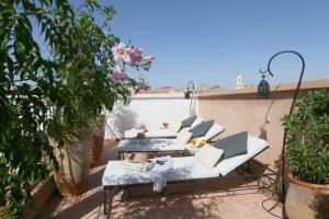 a patio with couches and tables on a balcony at Riad Baba Ali in Marrakesh