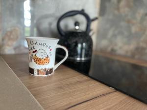 una tazza di caffè seduta su un tavolo accanto a un vaso di Wrota Biebrzy a Wroceń